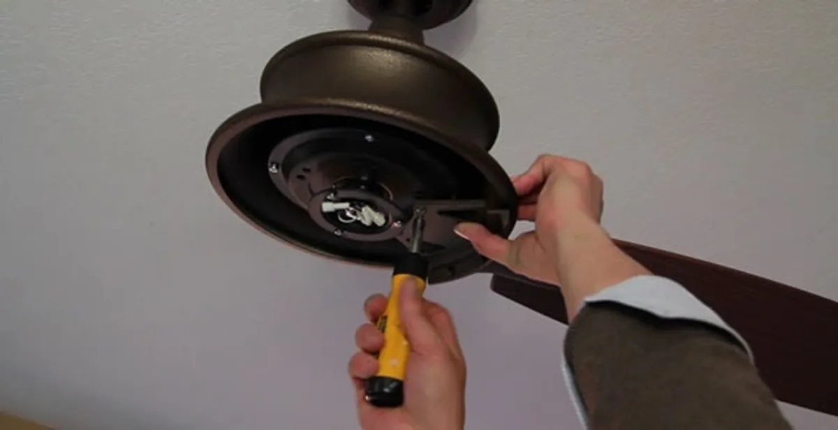 Electrician installing ceiling fan mounting bracket and fixture in Madison, WI