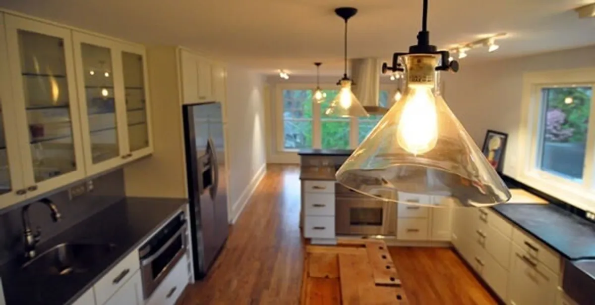 Residential electrician installing modern indoor light fixture in a home in Madison, WI